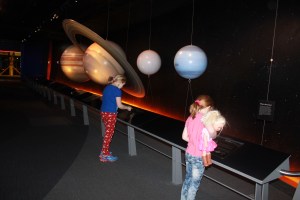 The  girls comparing weights on various planets at the Adventure Science Center